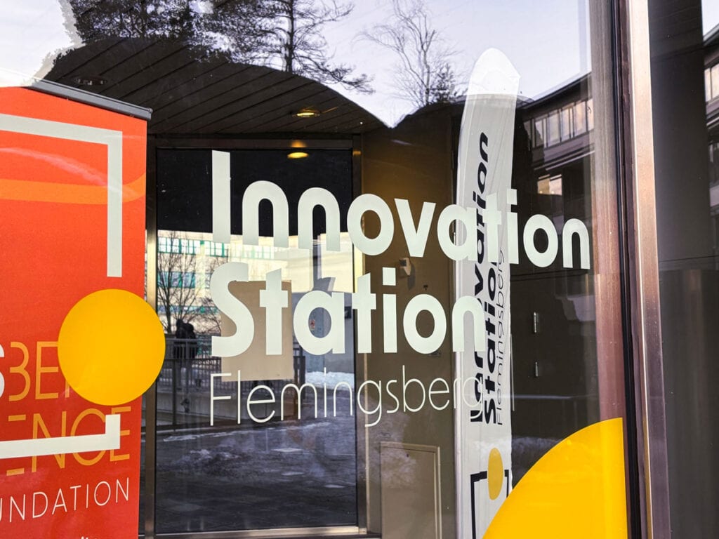 Entrén till Innovation Station Flemingsberg med logotyp på glasdörr och skyltar utanför lokalen.